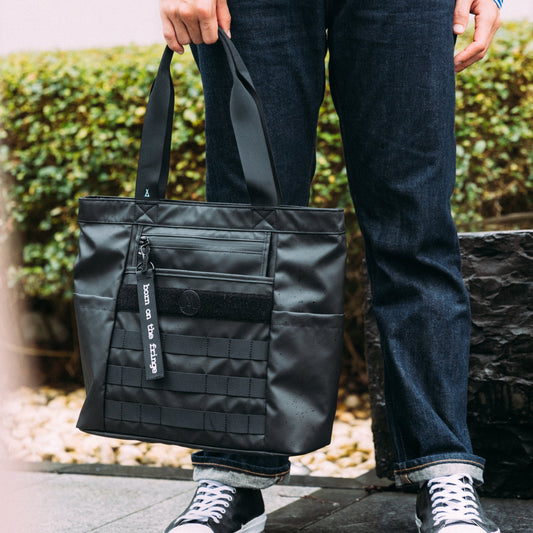 Moral NIGHTHAWKS MILITARY 軍事風托特包中碼戶外展示,展現防潑水材質與經典軍事風設計。包款實用耐看,適合日常通勤及休閒使用。