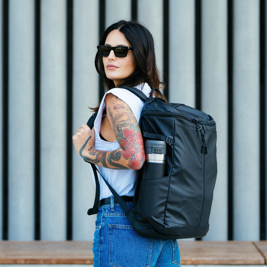 Moral Rochester Omni 雙肩背包 "L" - Stealth Bomber側面展示,展現包款立體輪廓與容量設計。側邊設有口袋,方便收納隨身物品。