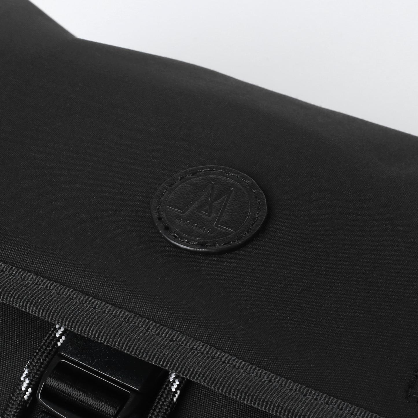 MORAL Northside Bostin 郵差包(中)黑色翻蓋，展現品牌低調質感標誌。細節設計突顯高級時尚品味。