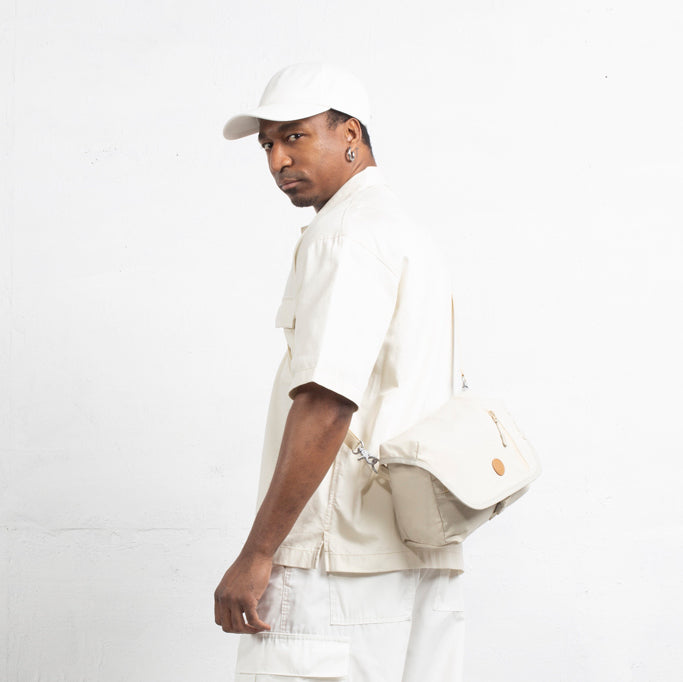 MORAL Northside Bostin 郵差包(中)以米白色設計，展現極簡時尚風格。模特側背包款，實用與造型兼具。